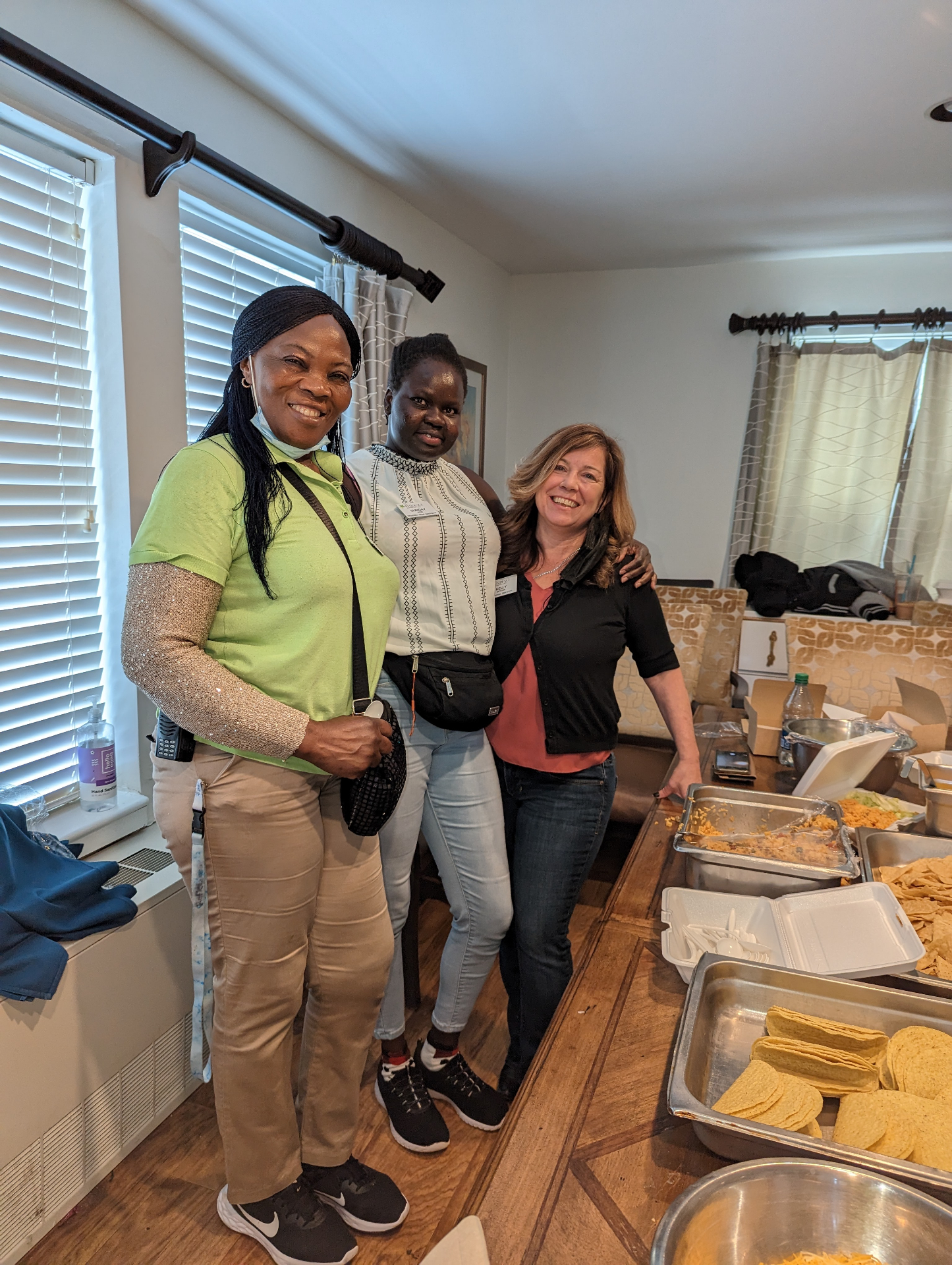Three Selena M Barach caregivers standing together at a community taco lunch.